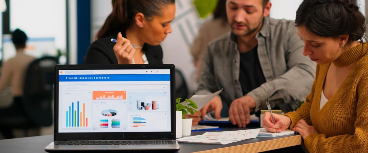 Group of people working at a table with a laptop